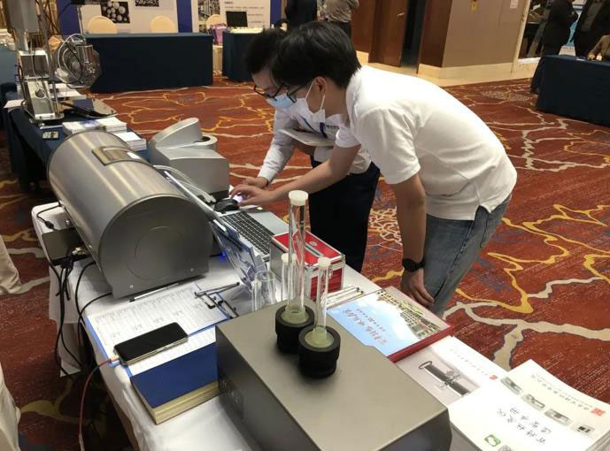 Bettersize team disscusing bettersizer 2600 with a customer at the National Innovation Development Forum for New Energy Powder Materials
